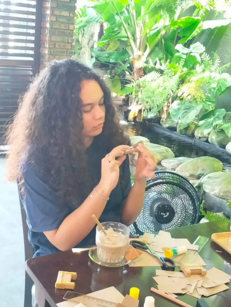 Student analyzing a complex cardboard mechanism